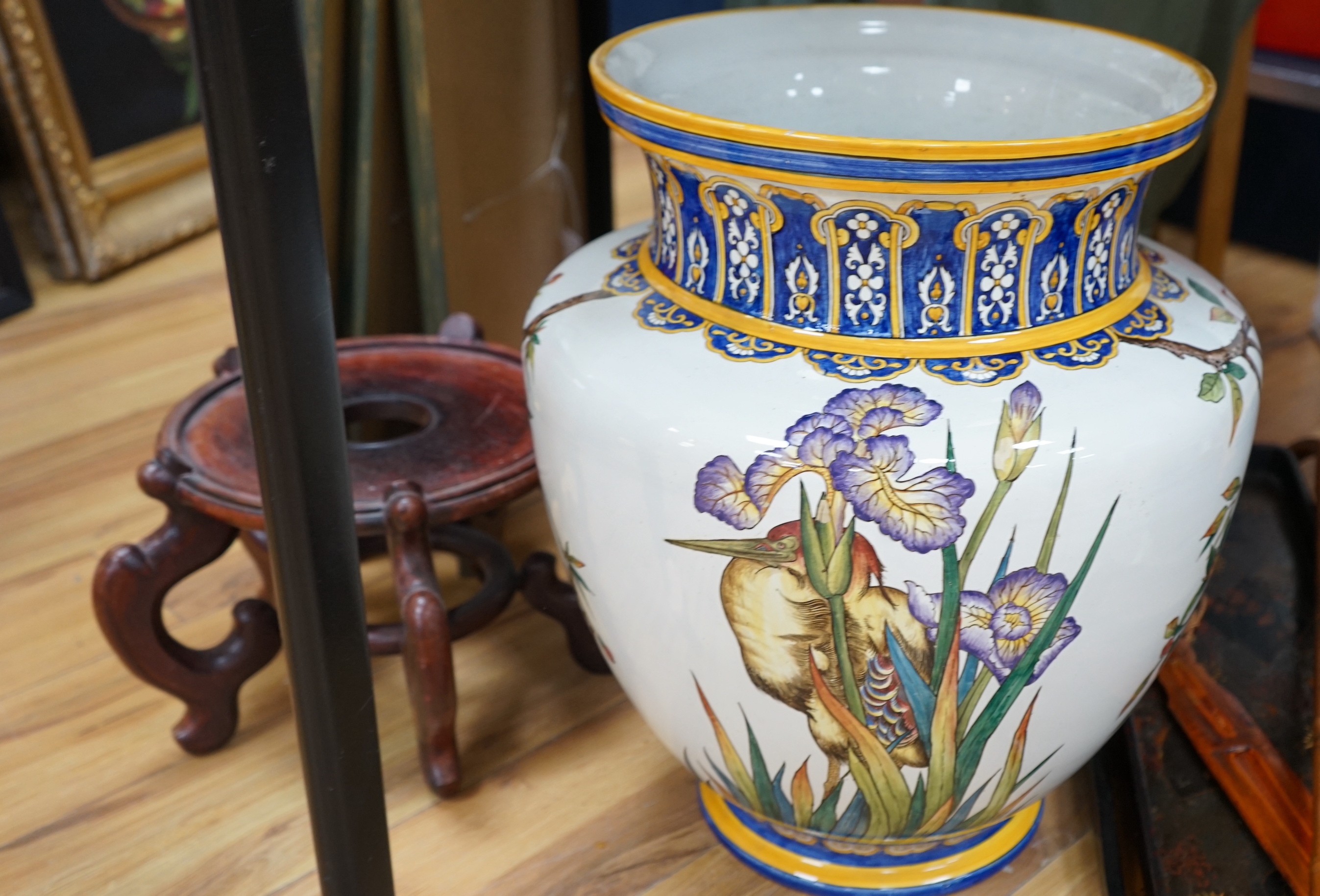 A Gien faience vase, painted with irises, raised on a hardwood stand, 68cm total height